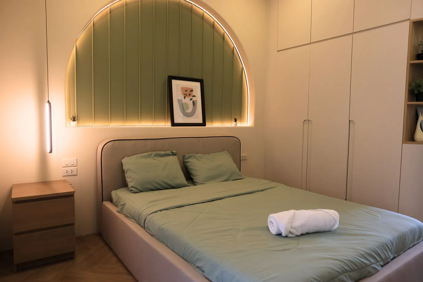 Bett mit sanft beleuchtetem grünem Kopfteil im Standardzimmer